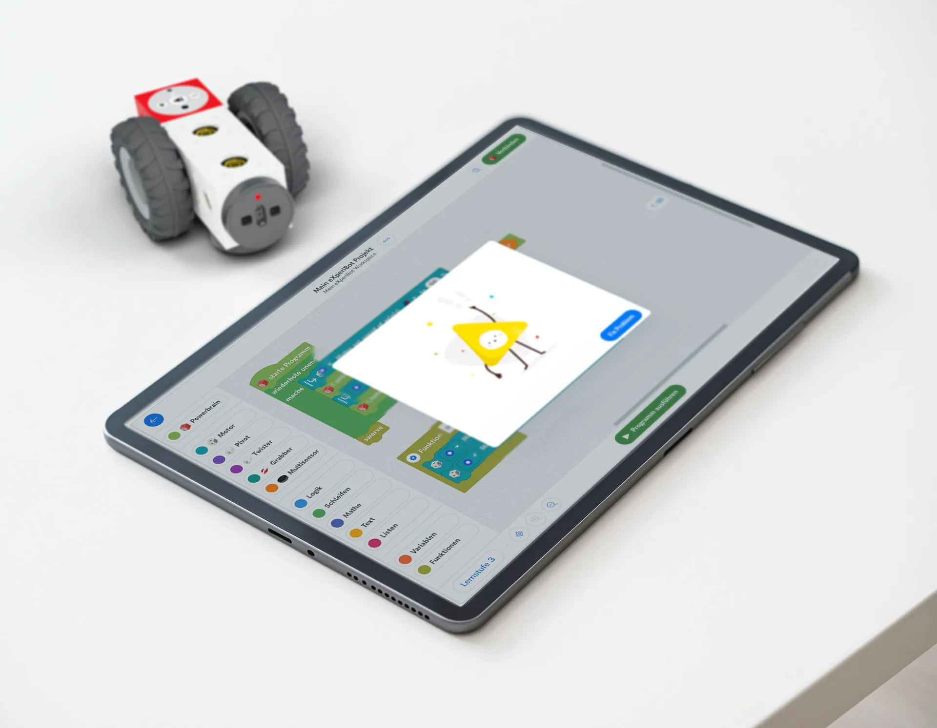 eXperiBot Explorer mit rot leuchtender Multisensor-LED und Tablet mit eXperiBot Blocky App, auf der eine Fehlermeldung angezeigt wird.